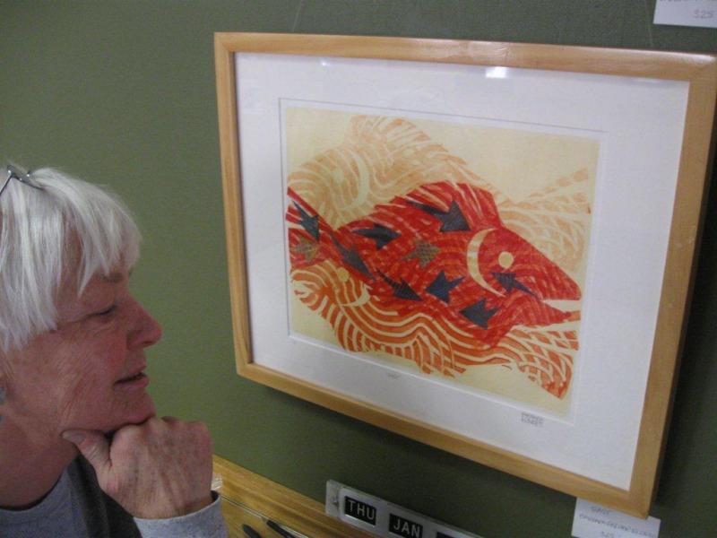 Barbara Fisher Eldred looks at a piece of her artwork at First Federal.
